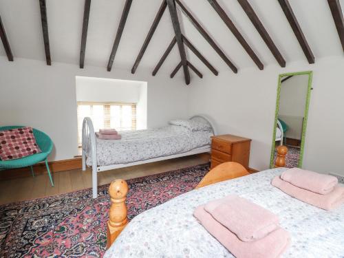 a bedroom with two beds and a mirror at Y Wennol in Llangefni