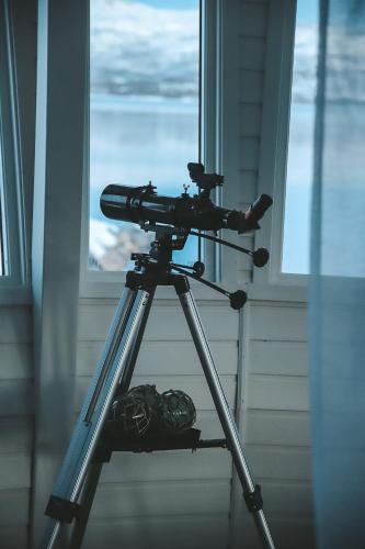 a camera on a tripod in front of a window at Norwegian Wild in Vangsvik