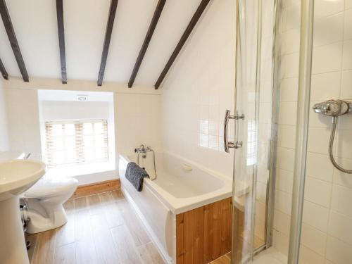 a bathroom with a shower and a tub and a toilet at Y Wennol in Llangefni