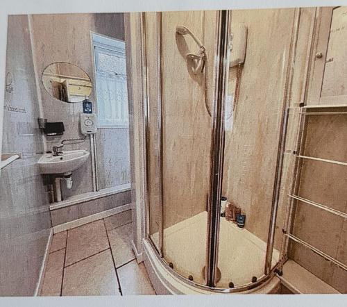 uma casa de banho com um chuveiro e um lavatório. em Hillview em Brean