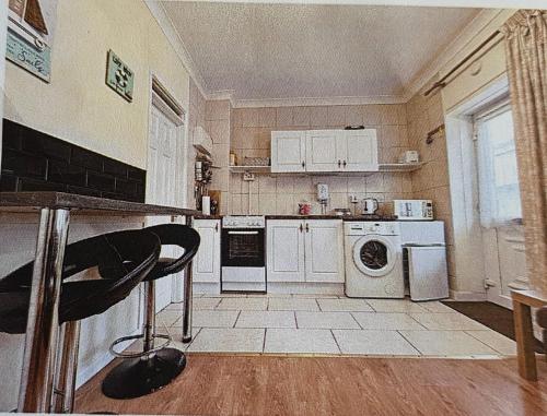a kitchen with white appliances and a chair in it at Hillview in Brean