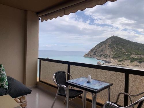 balcón con mesa y vistas al océano en Apartamento en Cala de Finestrat - Edificio Atalaya 5º 10 en Cala de Finestrat