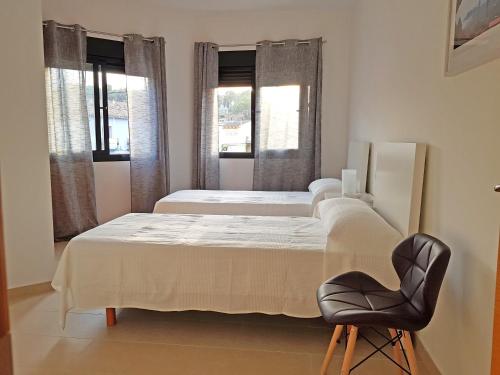 - une chambre avec 2 lits et une chaise dans l'établissement Sunny apartment great for Cycling, 300mb wifi, à Xaló