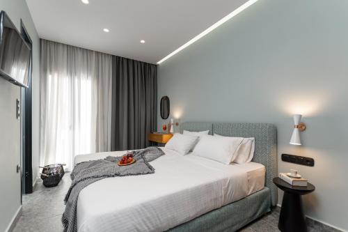 a bedroom with a large white bed and a window at Argo Boutique Hotel in Naxos Chora
