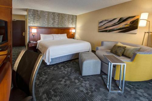 um quarto de hotel com uma cama e um sofá em Courtyard by Marriott Anchorage Airport em Anchorage