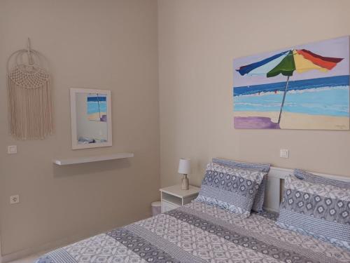 a bedroom with a bed and a painting on the wall at Giulias beach house in Theologos