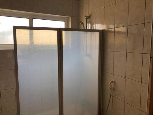 a shower with a glass door in a bathroom at Spacious 2 bed Apt with pool & sea views in Sal Rei