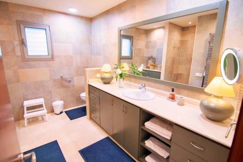 ein Badezimmer mit einem Waschbecken und einem großen Spiegel in der Unterkunft Bellviure Luxury Villa in Marratxí 