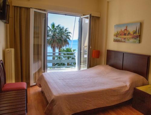 Hotel Lefkadi في ليفكاندي شالكيداس: غرفة نوم بسرير ونافذة كبيرة