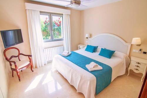 1 dormitorio con 1 cama, 1 silla y TV en Bellviure Luxury Villa, en Marratxí 