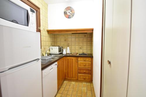 uma pequena cozinha com um frigorífico e um lavatório em Entrade - Seignosse - Villa patio dans quartier calme entre le Golf et les Plages em Seignosse