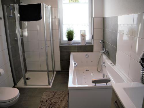 bagno con vasca, doccia e servizi igienici di FeWo Sonnenschein mit Whirlpoolbadewanne a Bad Harzburg