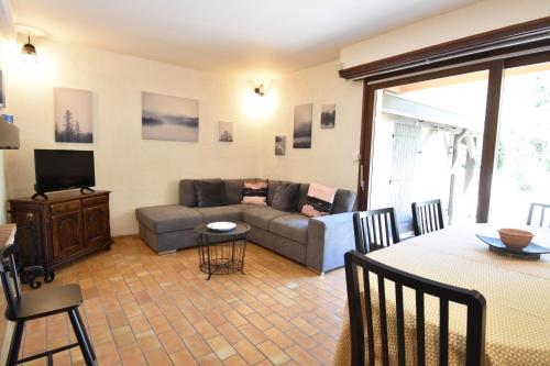 un salon avec un canapé et une télévision dans l'établissement Entrade - Seignosse - Villa patio dans quartier calme entre le Golf et les Plages, à Seignosse