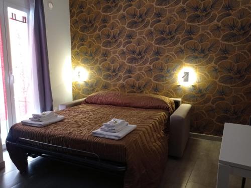 een slaapkamer met een bed met twee handdoeken erop bij La pergola home in Barletta