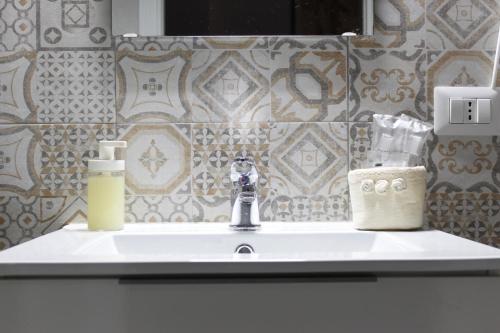 een wastafel met een zeepdispenser bij La pergola home in Barletta