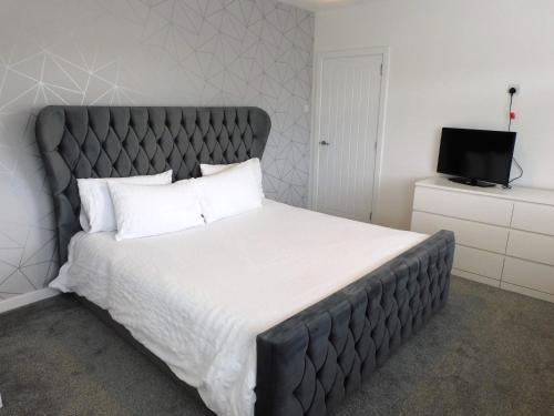 Säng eller sängar i ett rum på Beautiful 3 bedroom home with large garden 35 mins to Glasgow & Edinburgh