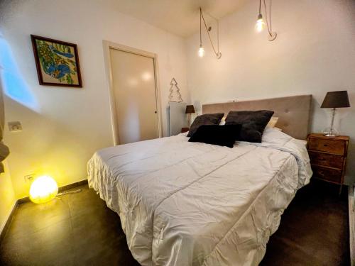 une chambre avec un lit avec un ordinateur portable dessus dans l'établissement Gretta - Patio, Cosy, WiFi - Ajaccio, à Ajaccio