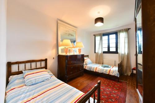 1 dormitorio con 2 camas, tocador y espejo en Bernet, en Labastide-Villefranche