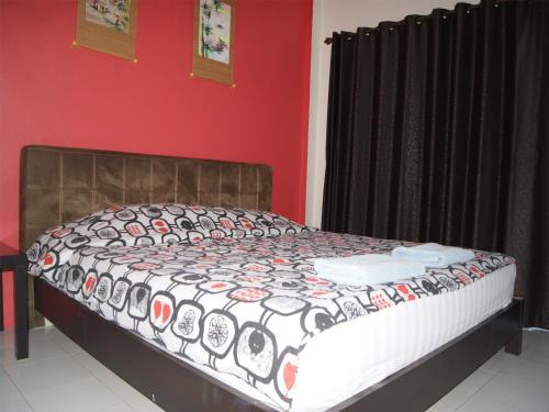a bed in a room with a black and red wall at Pineapple Guesthouse in Karon Beach