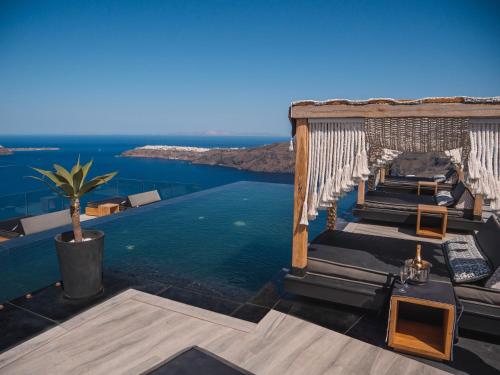 una piscina con sillas y vistas al océano en Galaxy Suites & Villas, en Imerovigli