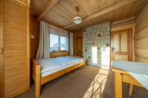 a bedroom with a bed in a wooden room at Willa Krokus in Zakopane