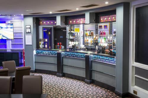 a bar in a room with chairs and lights at Airport Hotel Manchester in Manchester
