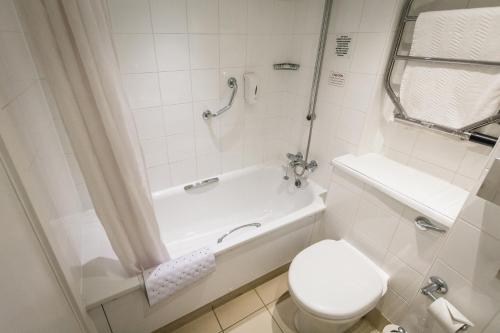 a bathroom with a tub and a toilet and a shower at Airport Hotel Manchester in Manchester