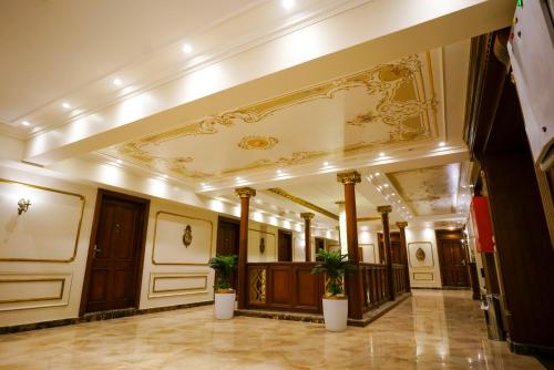 a hallway of a building with pillars and a ceiling at Savoy Hotel ELMinya in Al Minya