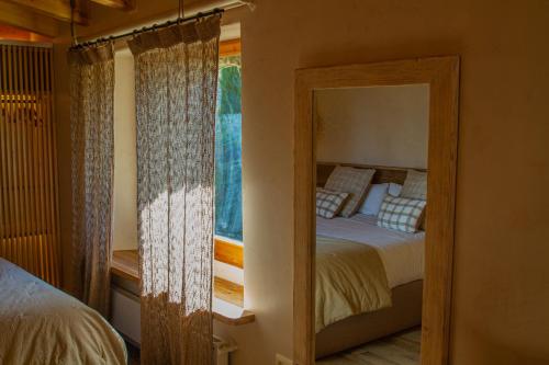 a bedroom with a bed with a mirror and a window at Santa Llúcia Rupit in Rupit