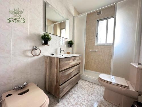 ein Badezimmer mit einem Waschbecken, einem WC und einem Spiegel in der Unterkunft Dos Torres Lacarra - Espacioso con 7 Camas Individuales in Saragossa