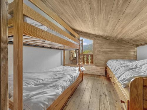 two bunk beds in a room with a window at Duplex 7 pers proche base de loisirs Carroz (ACL06) in Les Carroz d'Araches