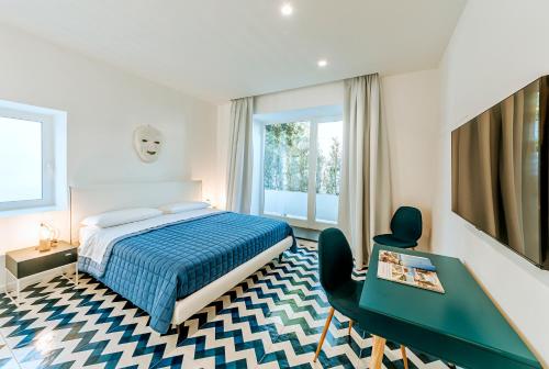 1 dormitorio con 1 cama, 1 mesa y 1 silla en Davalos 14 Luxury Home, en Isquia
