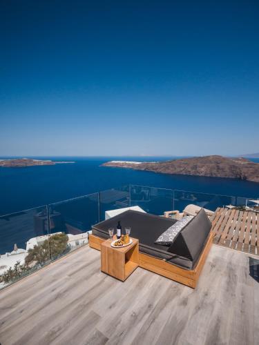 a balcony with a bed and a view of the ocean at Galaxy Suites & Villas in Imerovigli