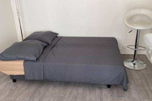 - une chambre avec un lit et une couette grise dans l'établissement Comfortable & bright Parisian studio!, à Ivry-sur-Seine