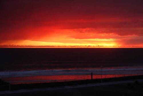a sunset over the ocean with a red sky at Bel appartement 4 personnes en front de mer in Lacanau