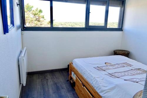 a small bedroom with a bed and a window at Bel appartement 4 personnes en front de mer in Lacanau