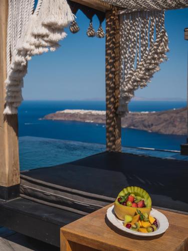 a plate of fruit on a table with a view of the ocean at Galaxy Suites & Villas in Imerovigli