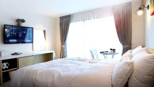 Ένα ή περισσότερα κρεβάτια σε δωμάτιο στο Tongyeong Bay Condo Hotel