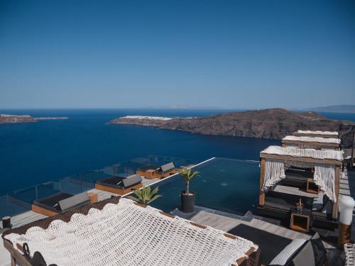 an aerial view of a swimming pool and the ocean at Galaxy Suites & Villas in Imerovigli