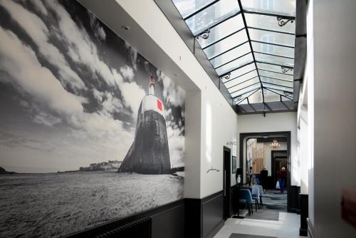 a hallway with a picture of a missile on the wall at Hotel De L'univers in Saint Malo