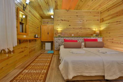 a bedroom with two beds in a wooden cabin at Çıralı Orange Motel in Cıralı