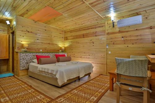 a log cabin bedroom with a bed and a desk at Çıralı Orange Motel in Cıralı