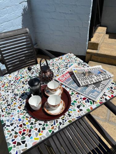 a table with a tea set on a mosaic table cloth at The Laurels Hotel in Skegness