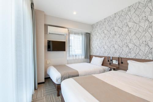 Habitación de hotel con 2 camas y TV en Hotel Sanrriott Osaka Hommachi en Osaka