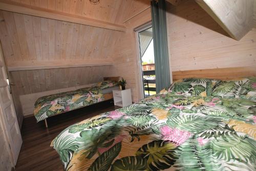 a bedroom with two beds in a wooden room at Domki Perłowe in Dąbki