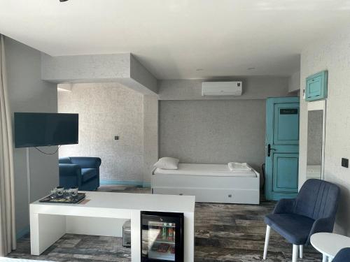 a living room with a white table and blue chairs at Villa Oliva Butik Hotel in Bodrum City