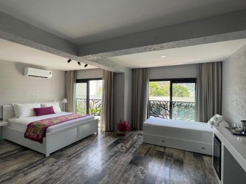 a bedroom with two beds and a balcony at Villa Oliva Butik Hotel in Bodrum City