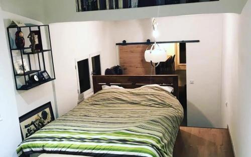 - une chambre dotée d'un lit avec une couverture verte et blanche dans l'établissement Appartement chaleureux et atypique avec jardin à Marseille by Weekome, à Marseille