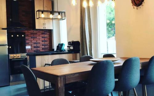 une cuisine avec une table en bois et des chaises bleues dans l'établissement Appartement chaleureux et atypique avec jardin à Marseille by Weekome, à Marseille