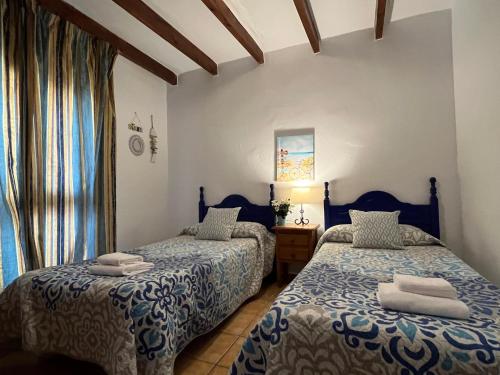 a bedroom with two beds and a window at Nerja Paradise Rentals - Villa Alminares in Nerja